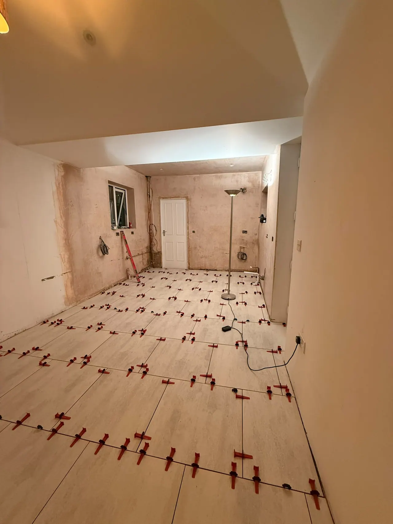 Floor tiling in progress with levelling clips on a room renovation in Essex