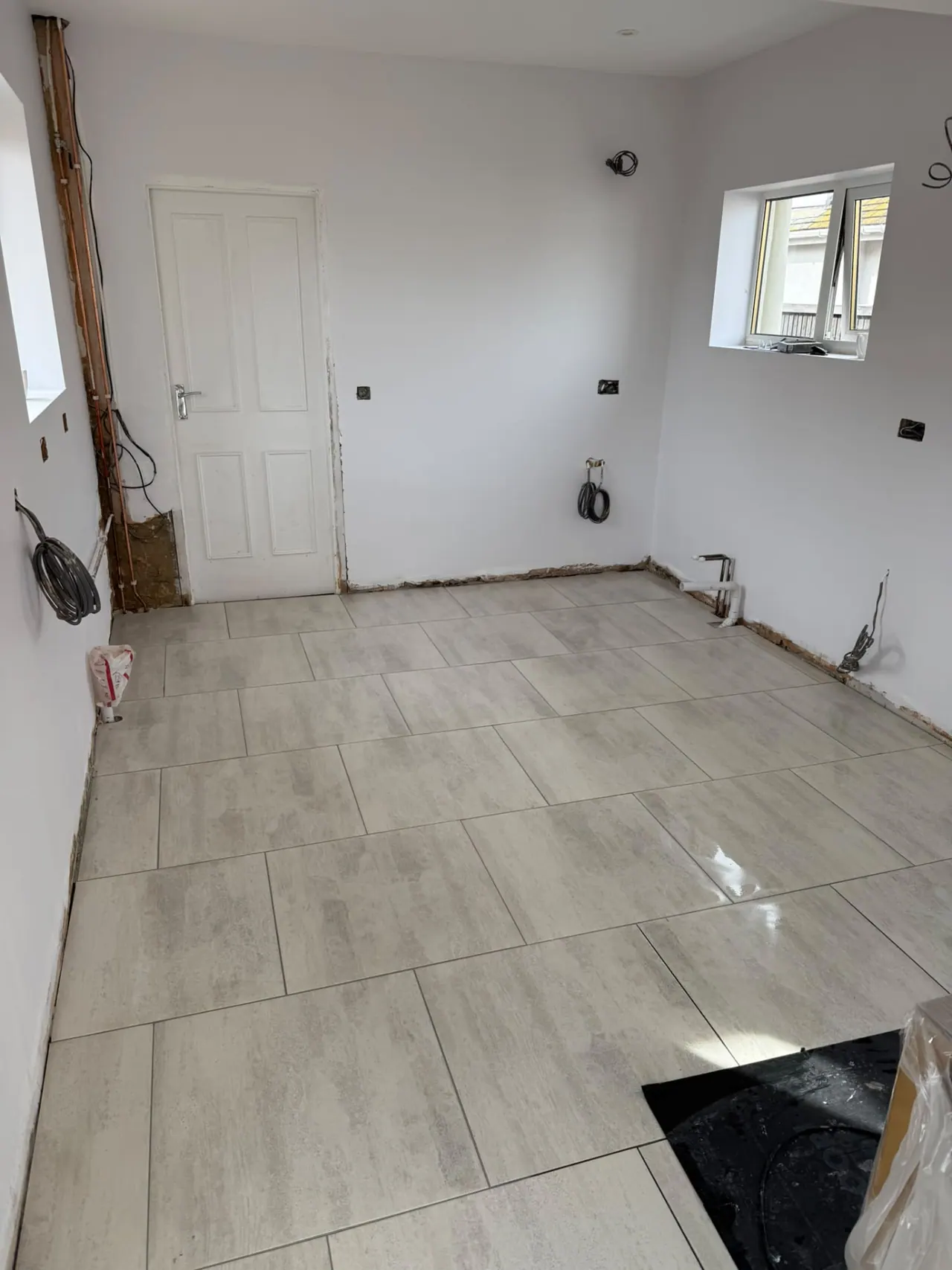 Large-format floor tiling completed in an open-plan room in Essex