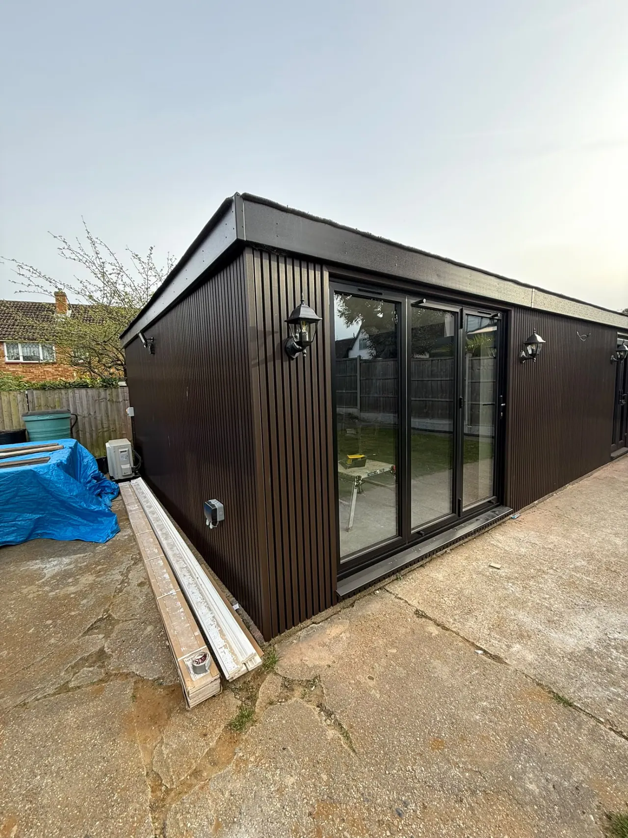 Completed garden room with dark cladding and sliding glass doors in Essex